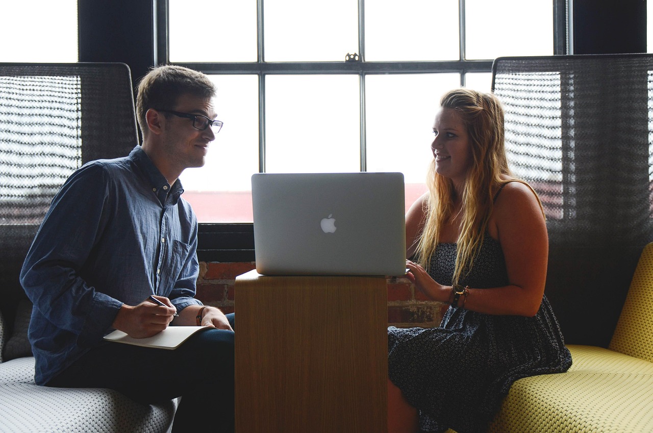 Two solopreneurs collaborating during a focused work session, building systems and staying accountable to business goals.